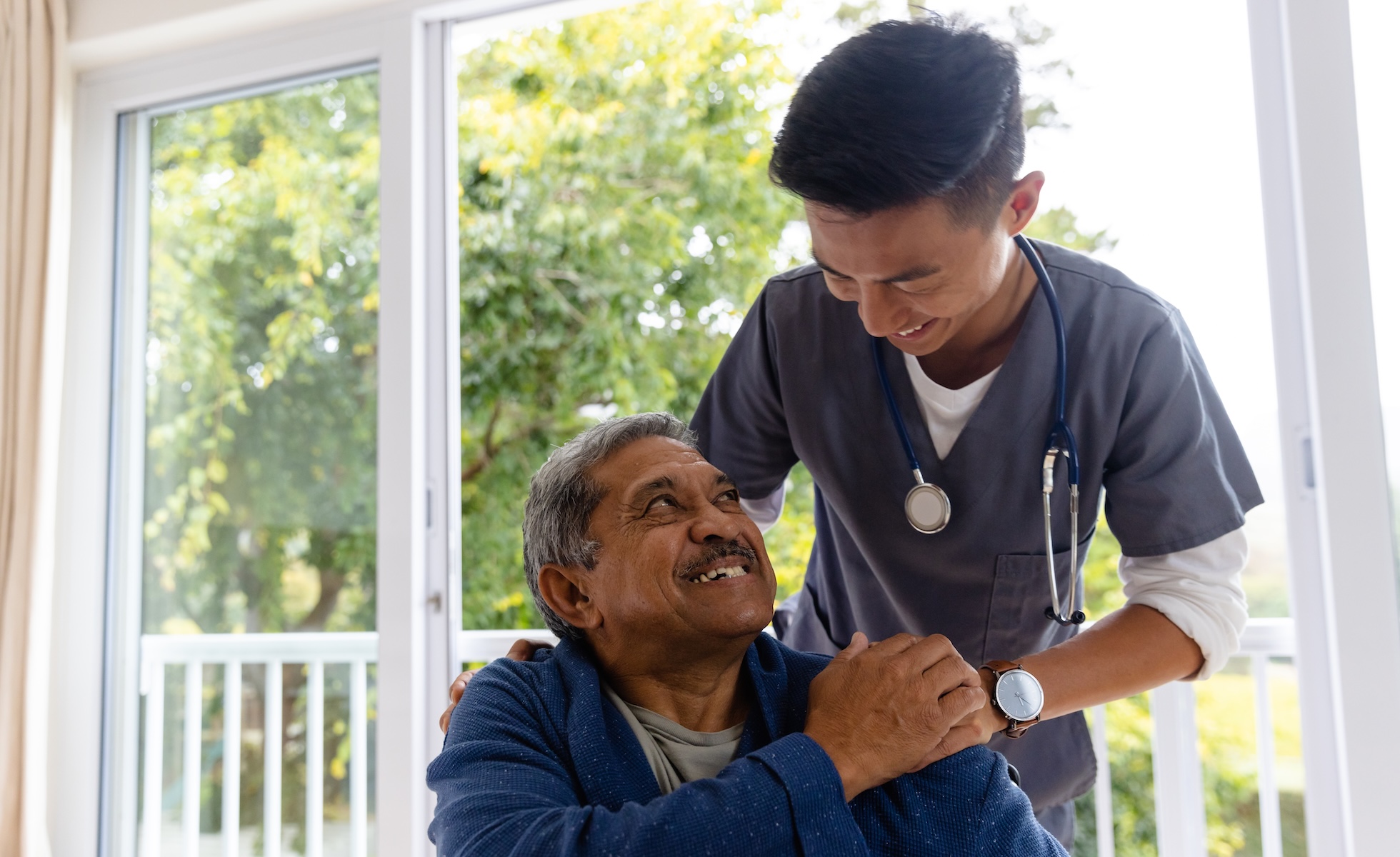 Patient in wheelchair smiling at cancer treatment nurse